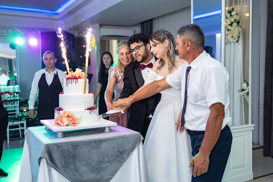Bride and groom cutting beautiful tiered wedding cake